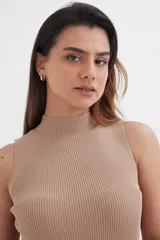 Top color beige de tejido de punto acanalado, sin mangas y con cuello alto.