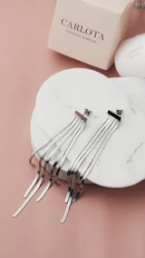Aros largos plateados con base cuadrada y flecos de cadenas finas.