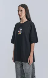 Remera negra de manga corta con cuello redondo y calce oversize. Estampado frontal de Mickey Mouse andando en skate.