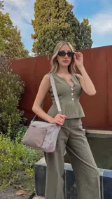 Bandolera de diseño moderno, color beige rosado, con correa regulable y bolsillo frontal con cierre.