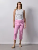 Pantalón capri color rosa de tencel elastizado con bolsillos simulados en la parte delantera y bolsillos aplicados en la parte trasera. Tiene pretina ancha, corte recto y terminación de ruedo desflecado.
