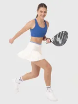Falda blanca plisada con pretina elástica con detalles de líneas de color y calza incorporada con bolsillo. Ideal para tenis o pádel.