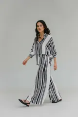 Pantalón blanco con rayas verticales negras, de tiro alto y corte palazzo.