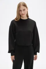 Buzo color marrón con cuello redondo y mangas largas abullonadas.