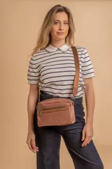 Bandolera color rosa viejo con detalles en cuero marrón claro, múltiples cremalleras metálicas y herrajes plateados. Incluye correa ancha ajustable con el logo de la marca.