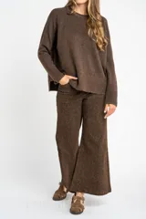 Sweater color marrón claro de tejido de punto, con cuello redondo y mangas largas.