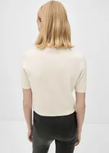Jersey de cashmere color crema, con cuello alto y mangas cortas.