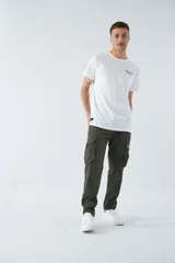 Pantalón cargo color marrón, corte slim, con cierre y botón en la cintura, pasacintos y bolsillos cargo con botones.