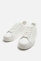 Zapatillas urbanas bajas color blanco, con cordones y suela plana.