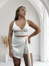 Short de vestir color blanco con corte de pollera cruzada y lazo lateral con hebilla metálica.
