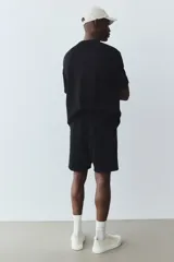 Short negro de felpa liviana de mezcla de algodón, con cintura elástica y cordón para ajustar, bolsillos al bies y un bolsillo abierto atrás.