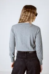 Cardigan gris de tejido de punto con cuello redondo y cierre frontal con botones.