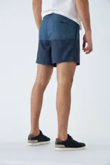 Short de baño celeste con estampado de líneas curvas en azul. Cuenta con cintura elástica con cordón ajustable, dos bolsillos laterales, un bolsillo trasero, suspensor interno y logo bordado.