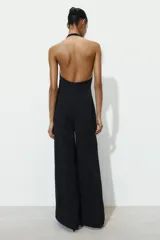 Mono largo negro de cuello halter y espalda descubierta, con pierna ancha. Cierre en espalda con cremallera oculta en costura y botones.