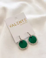 Aros colgantes con aro de acero plateado y dije circular forrado en tela verde esmeralda con borde de strass plateado.