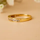 Anillo de oro amarillo 18k con circonias engarzadas en la mitad superior.