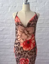 Vestido largo de microtul con estampado animal print y flores rojas. Tiene espalda descubierta con tiras finas cruzadas.
