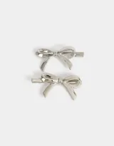 Set de dos hebillas plateadas para el pelo con forma de moño.