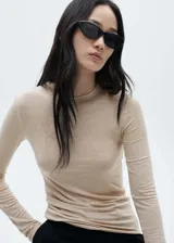 Remera color beige de manga larga y cuello redondo, de corte ajustado.
