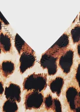 Traje de baño enterizo con estampado animal print de leopardo en tonos marrones y negros. Tiene escote en V, espalda descubierta y tirantes finos que se atan al cuello.