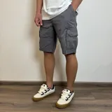 Bermuda cargo gris de gabardina con bolsillos laterales con fuelle y solapa.