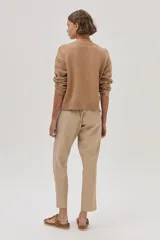 Cárdigan color camel de tejido de punto con trenzas en las mangas y cierre frontal con botones.