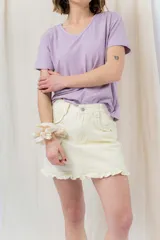 Minifalda de denim color crema con volados en los bolsillos delanteros y en el ruedo.