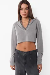 Top manga larga gris de tejido de punto con capucha y largo a la cintura. Cartera con botones al tono en delantero.