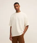 Remera color crema de poliéster y elastano con textura de pana, cuello redondo, manga corta y bordado centralizado de lettering minimalista.