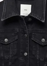 Chaqueta de jean negra con cuello de solapa, cierre frontal con botones, bolsillos laterales y bolsillos de parche con solapa abotonada en el pecho.