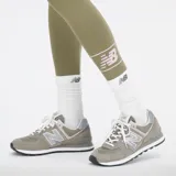 Calza larga color verde oliva de algodón con elastano, cintura alta y logo de New Balance estampado en blanco en la pantorrilla.