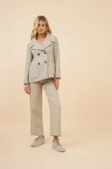 Chaquetón color crema con doble solapa, abrochadura doble, bolsillos delanteros y forro al tono.