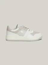 Zapatillas urbanas Tommy Jeans de corte bajo, con exterior de piel en tonos blanco, gris y beige. Presentan suela gruesa de goma, cordones y logo de la marca en el lateral y el talón.