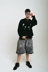 Bermuda de felpa gris oscuro con lavado gastado, corte ancho, estampado con serigrafía premium y bordado a un color.