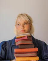 Billetera rectangular de cuero color naranja con cierre de cremallera y diseño geométrico en relieve.