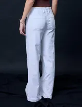 Pantalón de jean blanco de pierna ancha, tiro alto, pretina con pasadores, botón y cierre. Delantera y trasera con bolsillos.