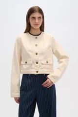 Chaqueta corta de algodón con estampado animal print en tonos grisáceos, cuello redondo, cierre frontal con botones a presión, bolsillos de parche en el pecho y corte recto.