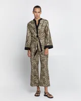 Pantalón negro con estampado dorado de motivos geométricos, corte flare y tiro alto.
