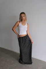 Pollera larga de fibrana color bordó con estampado de lunares blancos.