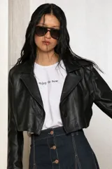 Remera blanca de algodón con ribete amarillo en cuello y mangas, y frase bordada en color naranja.