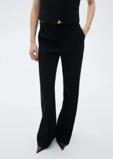 Pantalón de vestir negro de corte wide leg, con bolsillos laterales y cierre frontal con cremallera y botón.