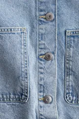Sobrecamisa celeste de denim con cuello clásico, botones frontales, canesú delantero y trasero, hombros caídos, puños abotonados, bolsillos de parche delanteros y bajo redondeado.