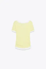 Camiseta blanca de corte slim fit, cuello redondo y manga corta con acabados en puntilla. Tiene detalle de frunces en los laterales y tejido combinado a contraste efecto doble en cuello, mangas y ruedo.