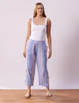 Pantalón capri de algodón a rayas verticales celestes, rosadas y beige. Tiene pretina elastizada, bolsillos delanteros y ruedo con botones.