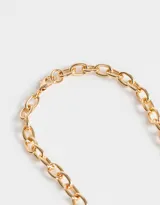 Collar corto dorado con cadena de eslabones gruesos y dije de corazón inflado.