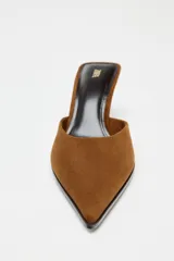 Zapato tipo mule destalonado color marrón, de ante, con escote redondo, punta fina y tacón medio fino.