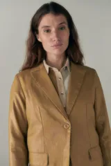 Blazer lila de lino con ruedo curvo, solapas con muesca, cierre frontal con un botón, bolsillos ojal con solapa y tajo en la espalda.