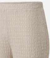 Pantalón largo color beige, de poliéster texturizado, con cintura elástica y bolsillos laterales.