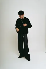 Pantalón de jean negro de corte baggy, con estampado de trigramas blancos en los bolsillos traseros.