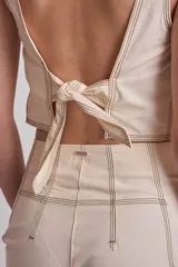 Blusa marrón sin mangas con pespuntes en contraste.